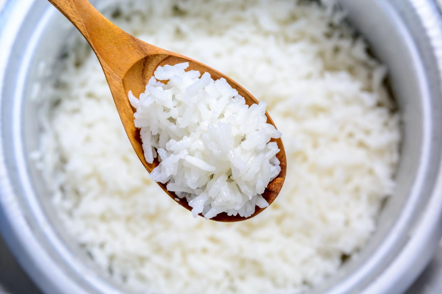 Cooked rice in pot with wood spoon