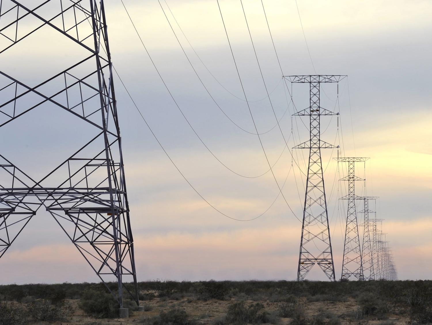 Row of high power lines stretches into the desert at sunset, Puerto Penasco, Mexico