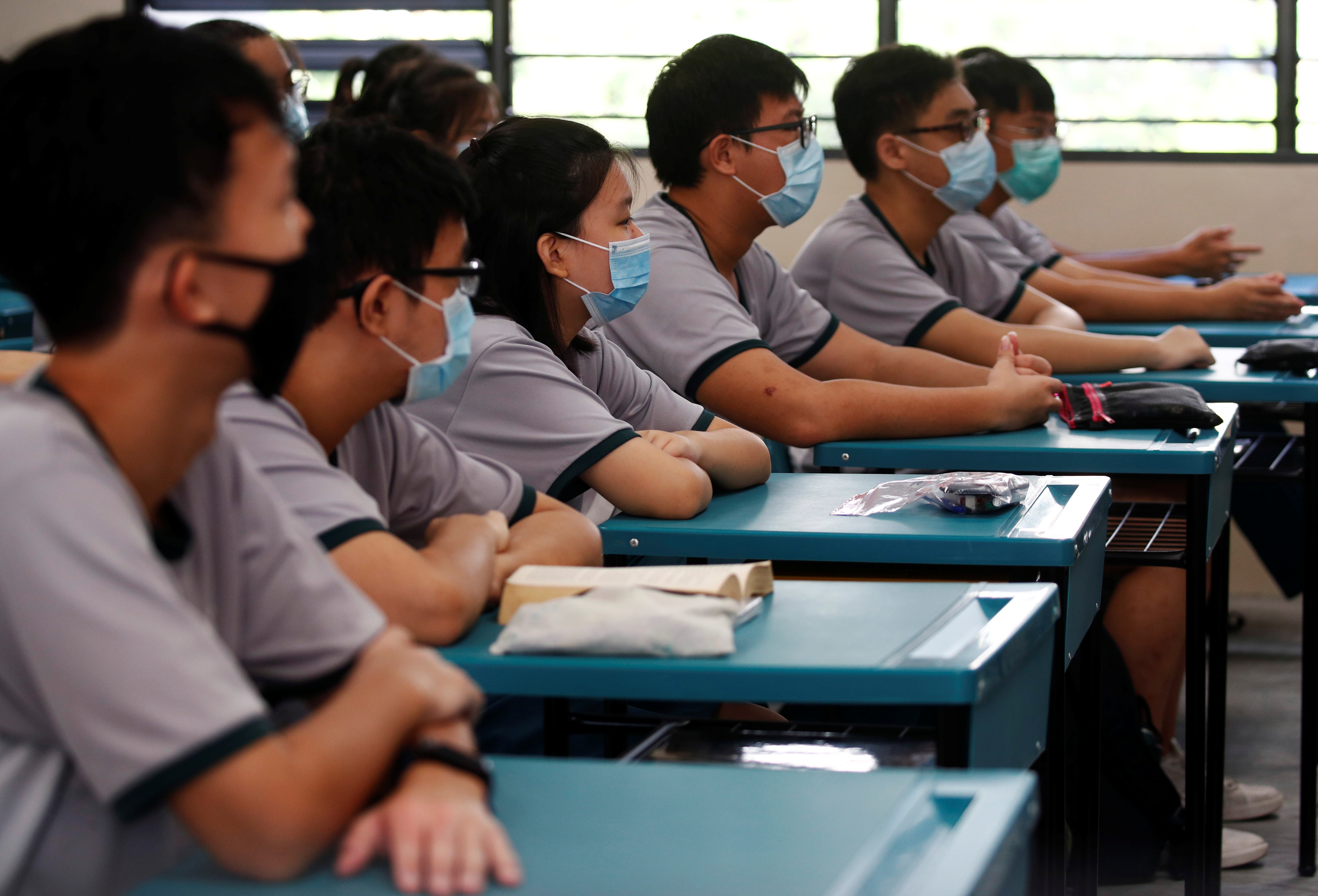 Students wearing protective face masks attend a class at Yio Chu Kang Secondary School, as schools reopen amid the coronavirus disease (COVID-19) outbreak in Singapore June 2, 2020.  REUTERS/Edgar Su