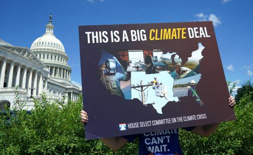 A volunteer holds a placard during a news conference on the climate crisis and the Inflation Reduction Act at the U.S. Capitol in Washington, D.C., U.S., August 12, 2022. REUTERS/Kevin Lamarque