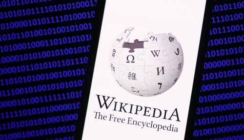 Wikipedia logo displayed on a phone screen and a binary code displayed on a screen are seen in this illustration photo taken in Krakow, Poland on January 19, 2023. (Photo by Jakub Porzycki/NurPhoto)NO USE FRANCE