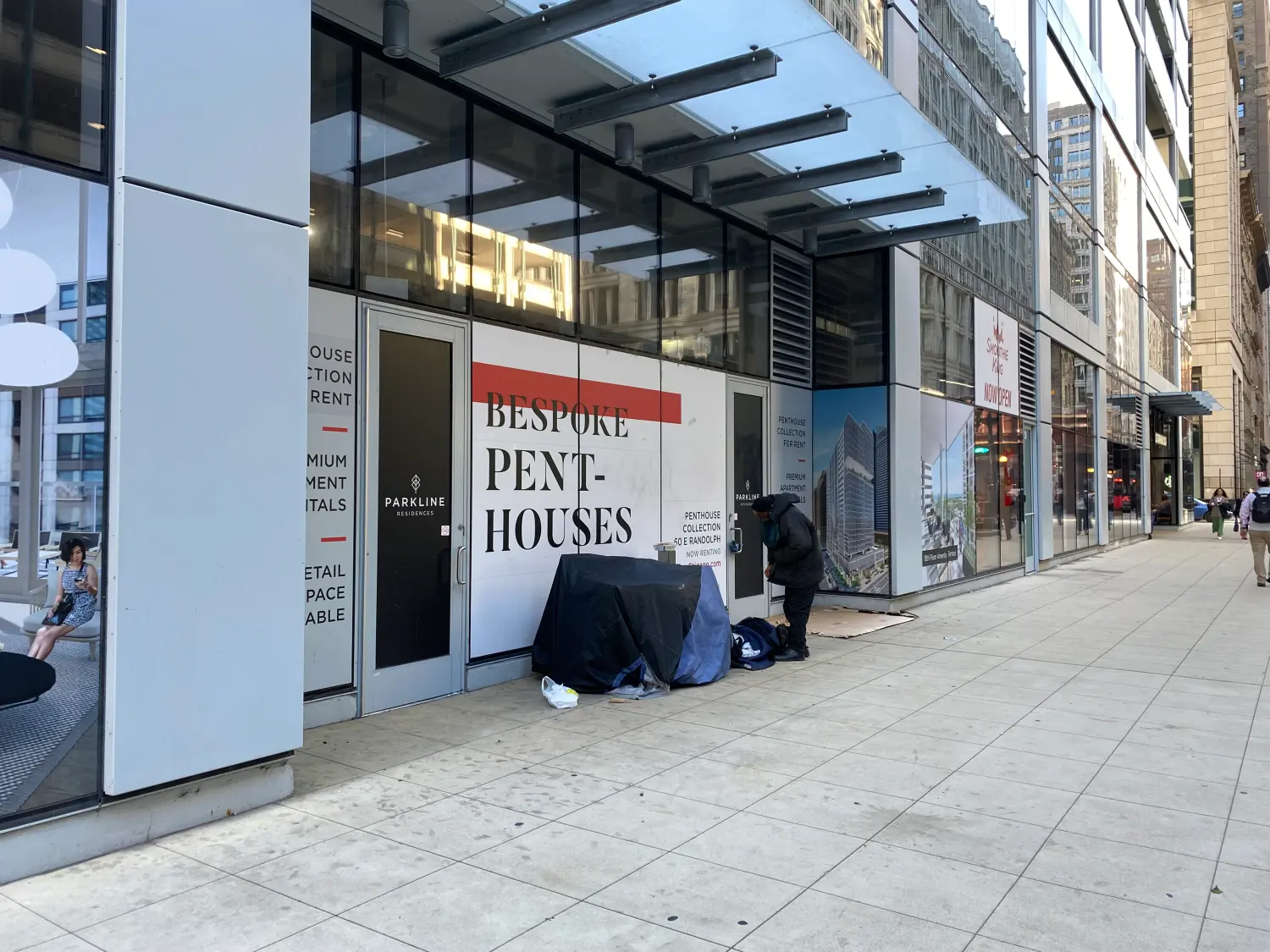 Downtown Chicago - homeless, black male outside of residence building advertising penthouse collection