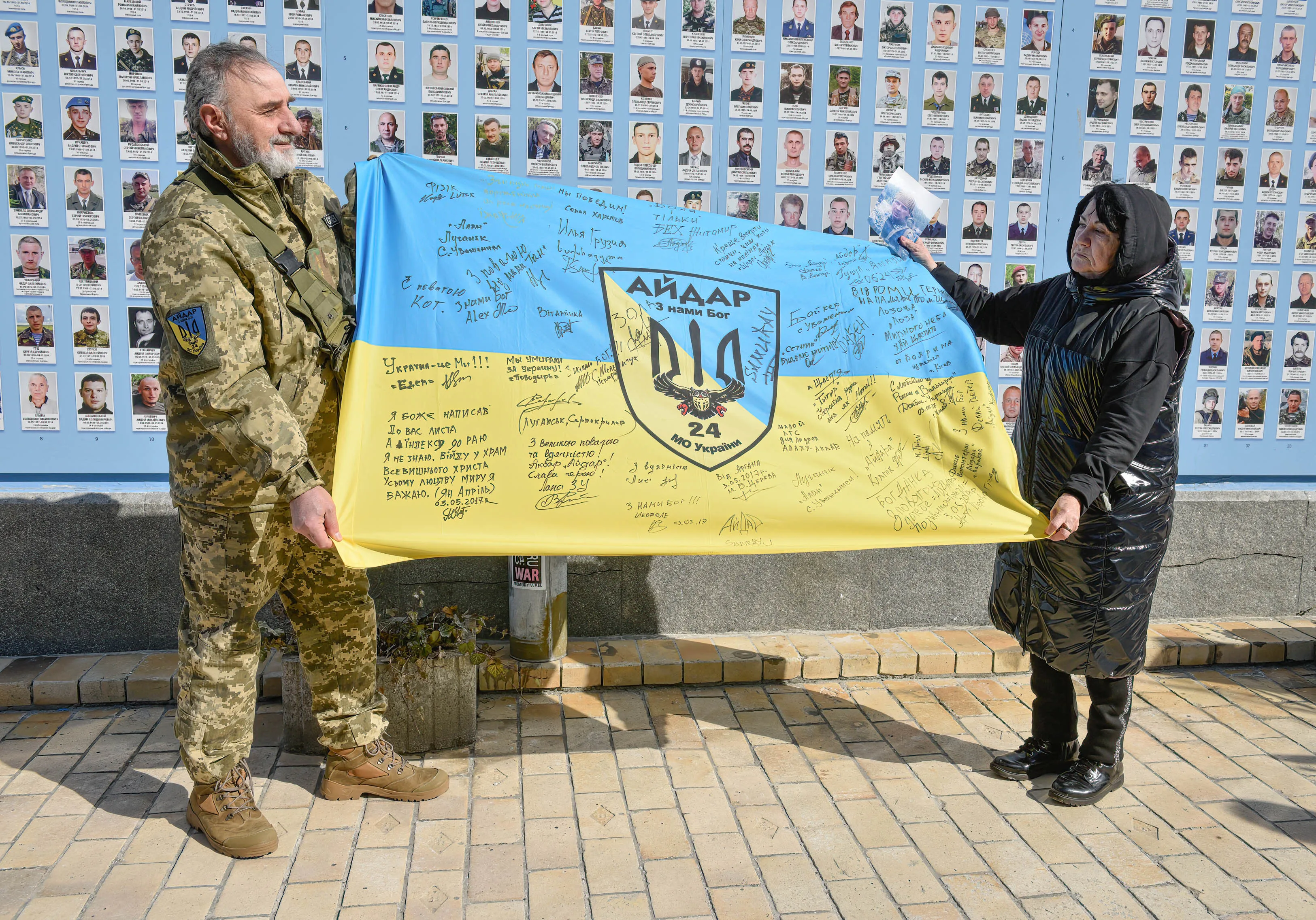 People hold the flag of the Aidar battalion near the wall of memory. "Volunteer's Day" was celebrated at the Wall of Memory of those who died for Ukraine, a commemoration of soldiers who died in the Russian-Ukrainian war. "Thanks to their courage and devotion to national interests, we managed to stop the aggressor country, to mobilise forces in the rear and arm the Ukrainian army". (Photo by Maksym Polishchuk / SOPA Images/Sipa USA)No Use Germany.