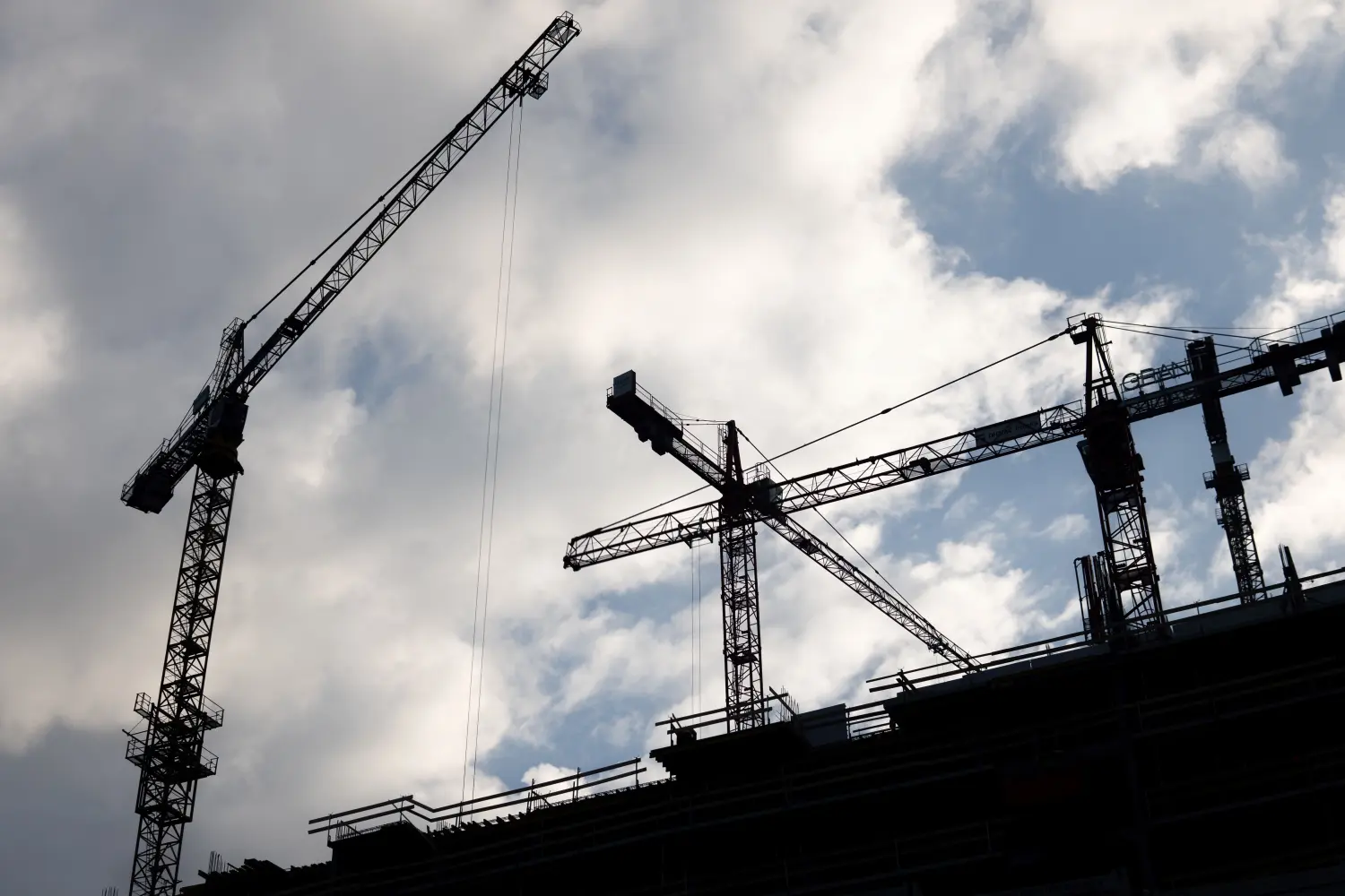 Constructions cranes against a cloudy sky