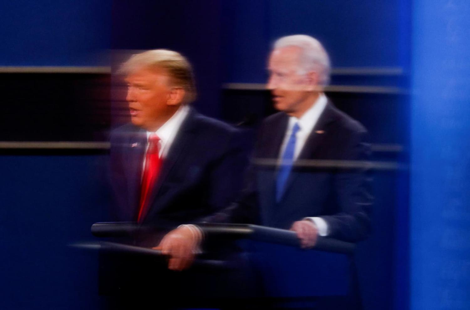 FILE PHOTO: U.S. President Donald Trump and Democratic presidential nominee Joe Biden are reflected in the plexiglass protecting a TV camera operator from coronavirus as they participate in their second 2020 presidential campaign debate at Belmont University in Nashville, Tennessee, U.S., October 22, 2020. REUTERS/Mike Segar/File Photo
