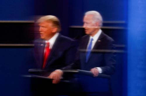 FILE PHOTO: U.S. President Donald Trump and Democratic presidential nominee Joe Biden are reflected in the plexiglass protecting a TV camera operator from coronavirus as they participate in their second 2020 presidential campaign debate at Belmont University in Nashville, Tennessee, U.S., October 22, 2020. REUTERS/Mike Segar/File Photo