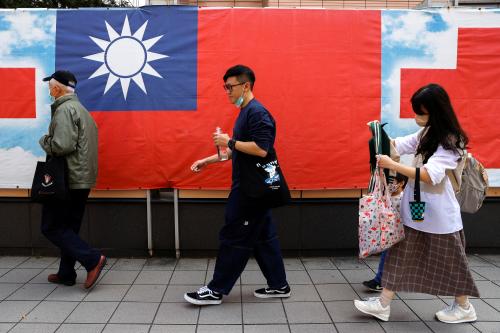 People walk past a Taiwan flag in Taipei, Taiwan, March 7, 2023. REUTERS/Ann Wang