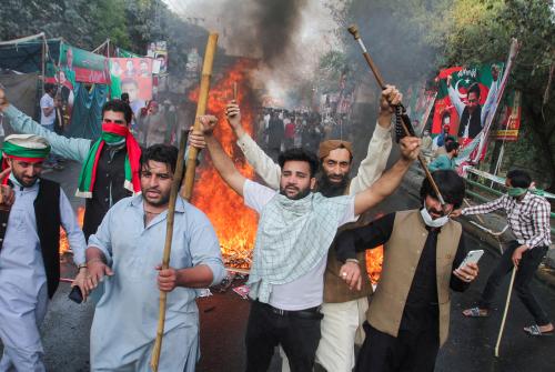 Supporters of former Pakistani Prime Minister Imran Khan, react as they blocked the road during clashes, ahead of Khan's possible arrest outside his home, in Lahore, Pakistan March 14, 2023. REUTERS/Mohsin Raza