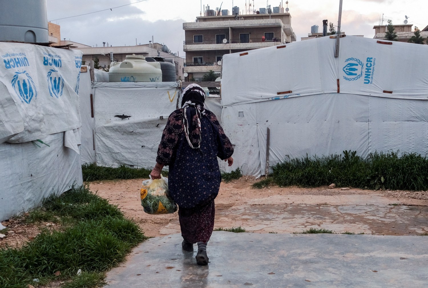 A Syrian refugee walks near tents, at an informal settlement, in Al-Marj, in Bekaa, Lebanon April 5, 2023. REUTERS/Emilie Madi