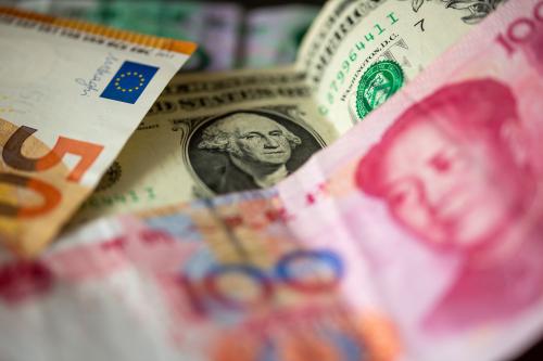 A Chinese 100 yuan banknote (front), a 1 U.S. dollar bill (M) and a 50 euro banknote (l) are lying on a table.