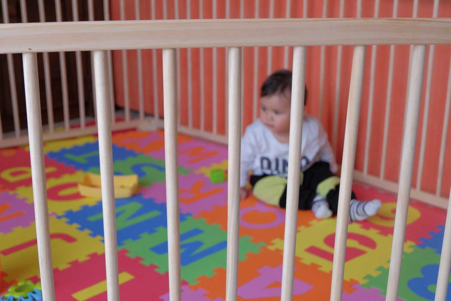 Baby alone in a playpen.