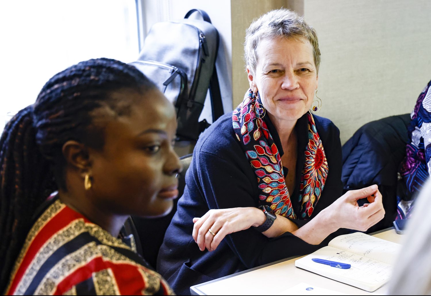 Two women seated during a meeting