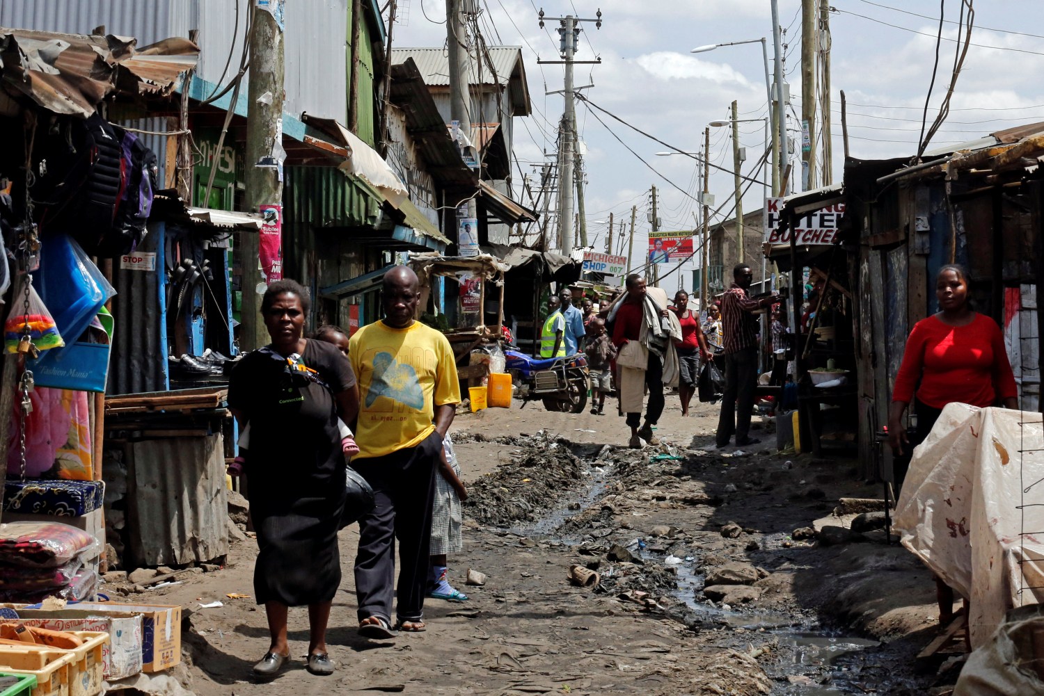 Residents walk along an alleyway with an open sewer at the Mukuru slum in Nairobi, Kenya July 19, 2017. REUTERS/Thomas Mukoya