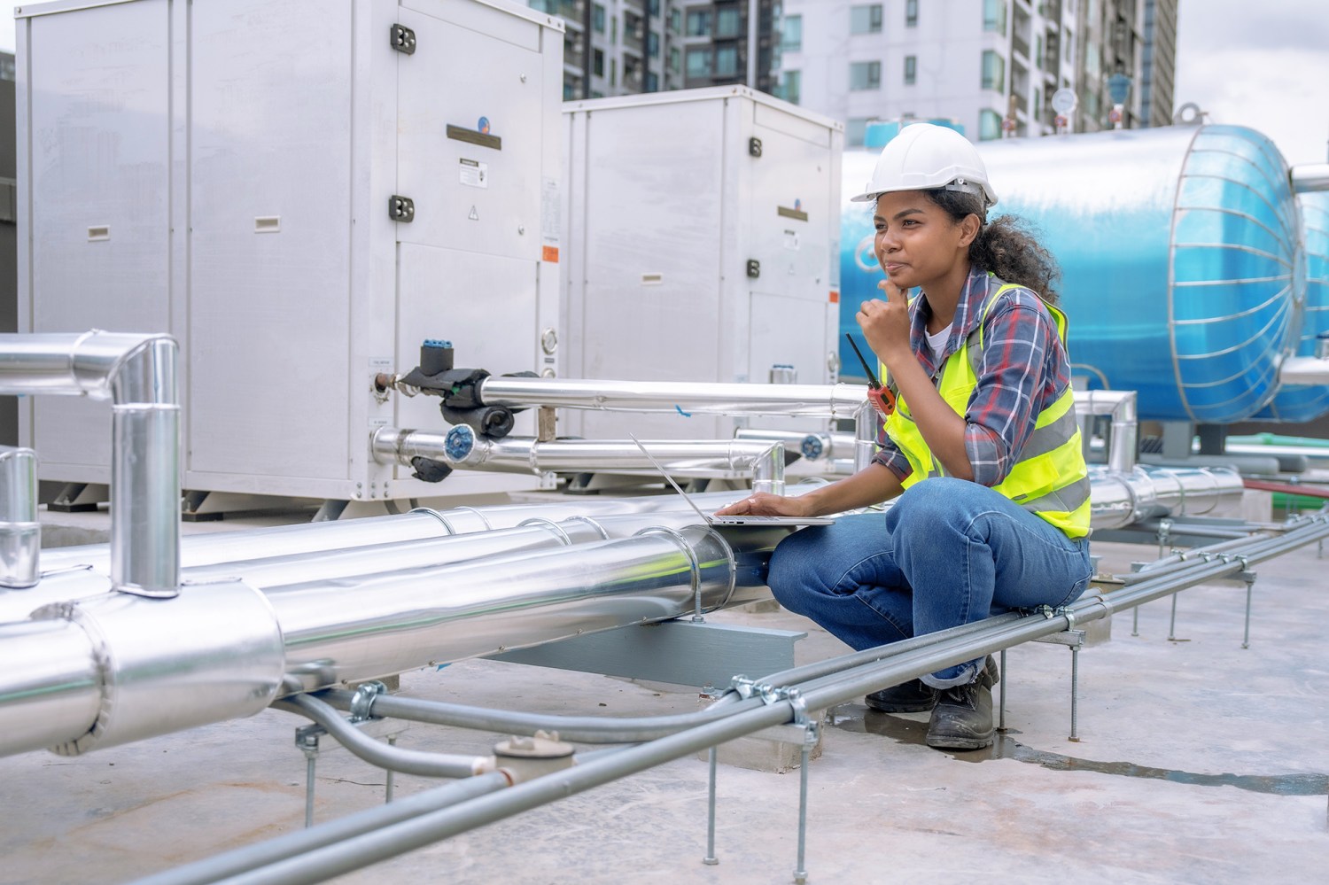 Female engineer inspects and controls the cooling system of a large factory air conditioner. Photo: Shutterstock