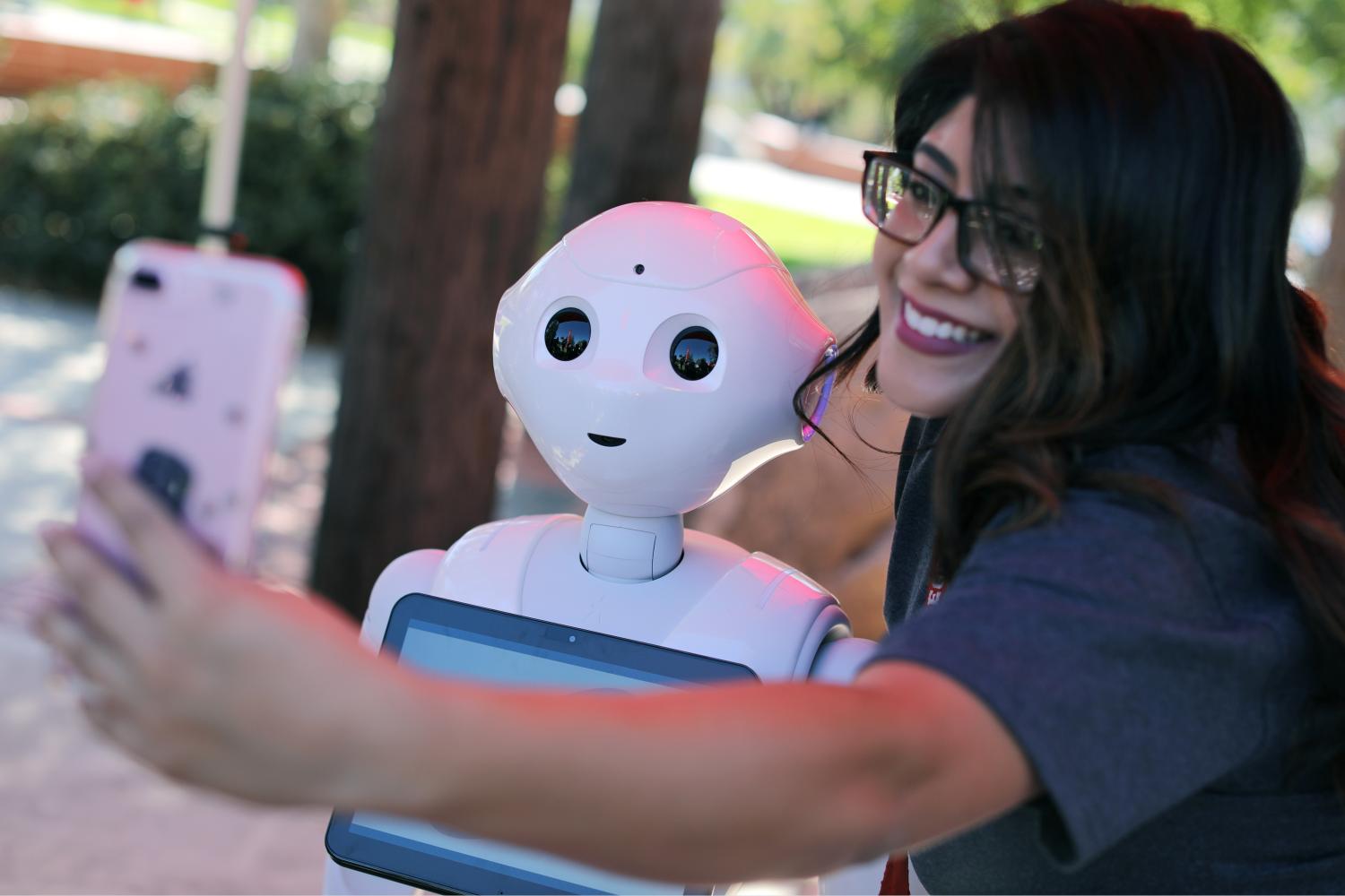 San Marcos student Amaris Gonzalez takes a selfie with "Pepper" an artificial Intelligence project utilizing a humanoid robot from French company Aldebaran and reprogramed as an assistant for students attending Palomar College in San Marcos, California, U.S. October 10, 2017. REUTERS/Mike Blake