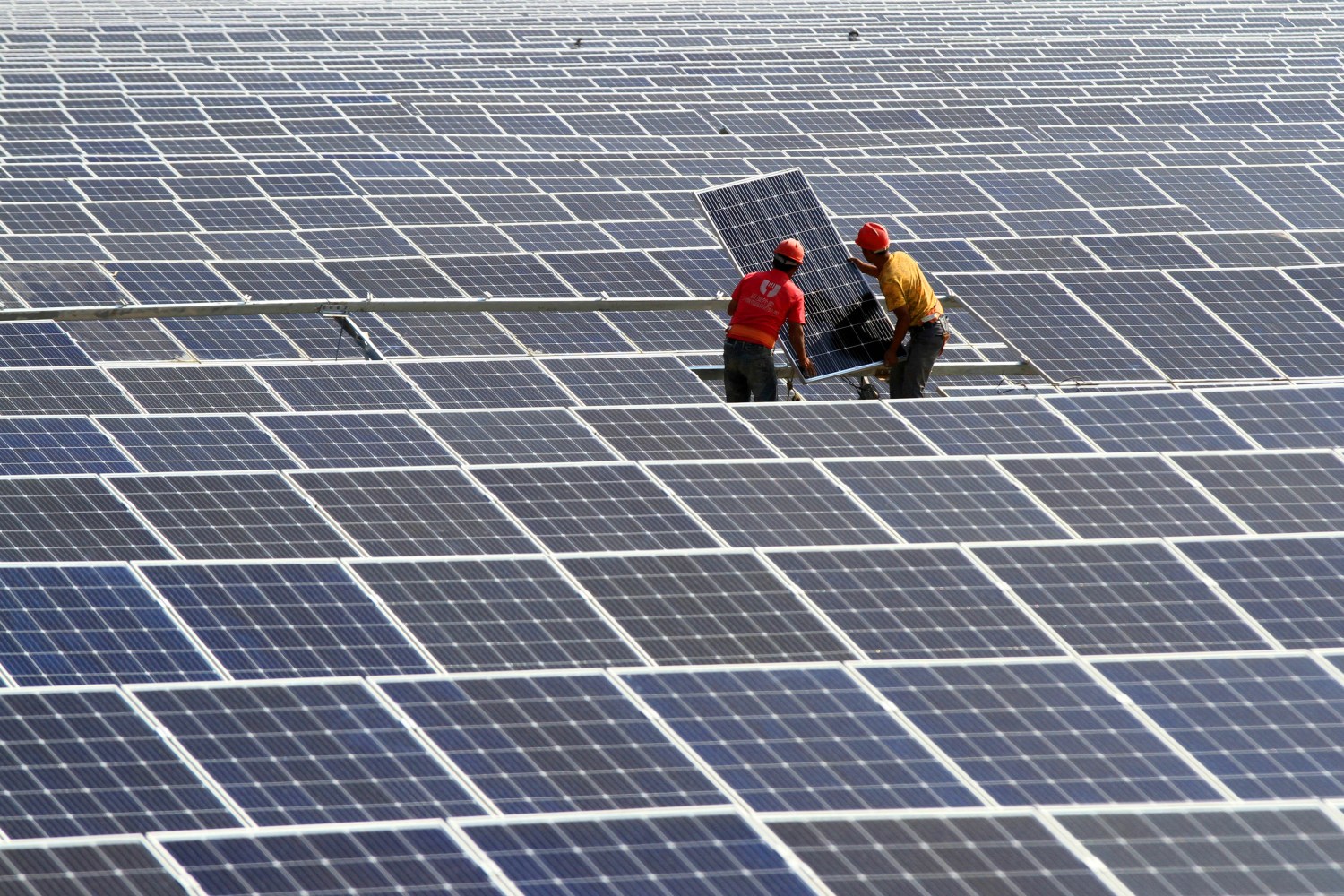 Chinese workers install solar panels at a photovoltaic power station in Huaian city, east China's Jiangsu province, 23 June 2018. Policy change reflected regulators' concerns that the industry has become "overprotected" with incentives resulting in excess capacity and wasted investment. With tightening policies, many of them are likely to fail, analysts said. The sunny summer for China's solar industry is seemingly coming to an end after regulators abruptly put the brakes on subsidies that have fueled the industry's boom for nearly a decade while also raising concerns of a glut.No Use China. No Use France.