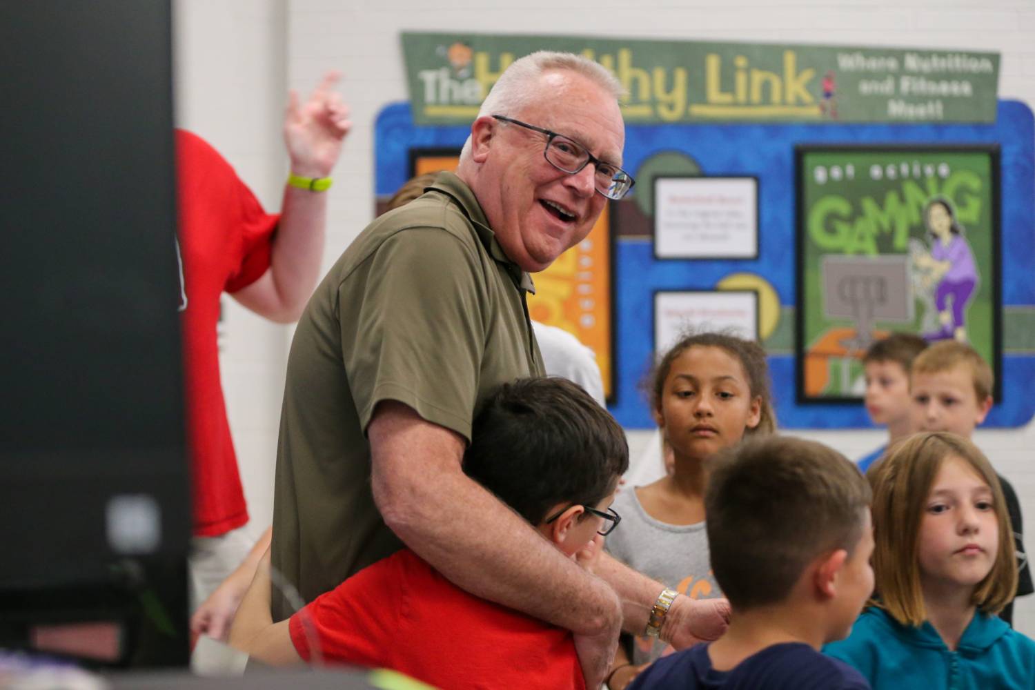 Rob Skaggs, Mintonye Elementary School principal, hugs his students after they held a surprise retirement celebration Skaggs, who will be retiring after serving as the school's principal for 24 years, on Wednesday, May 24, 2023, in Lafayette, Ind.