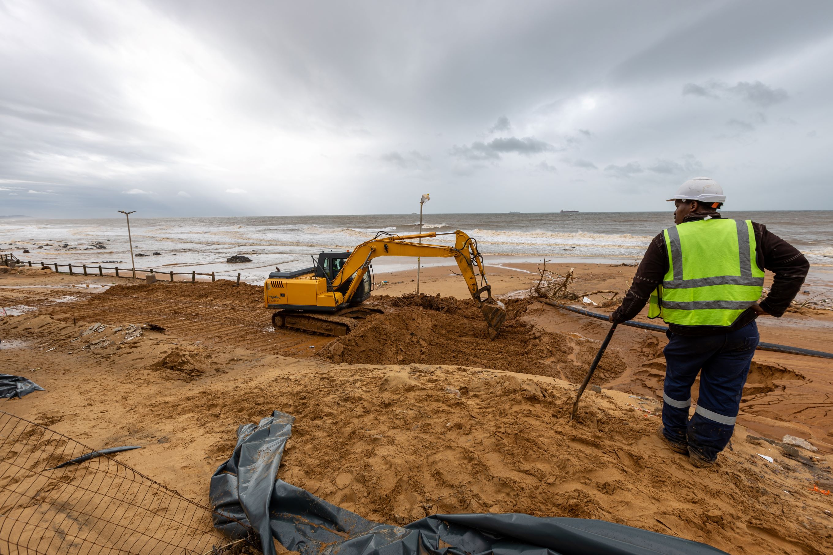 Durban, South Africa, 22 May 2022. A worker watches as construction machines clear a landslide caused by storms and flooding in the coastal city.