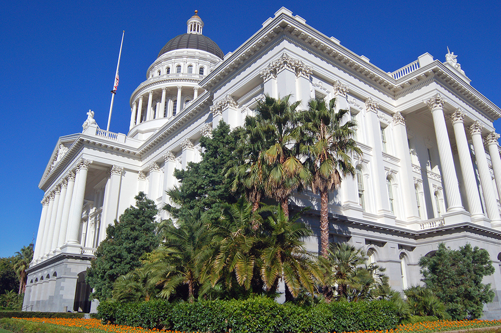 The California State Capitol Building in Sacramento, flag flying at half mast.
