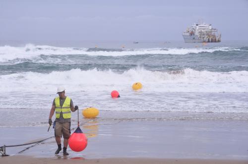A worker carries a buoy along a fiber optic cable from a cable laying ship at Arrietara beach, near Bilbao, northern Spain, June 13, 2017, as Facebook Inc. and Microsoft Corp. join forces to build an underwater fiber optic cable across the Atlantic Ocean, linking Europe and the USA. REUTERS/Vincent West