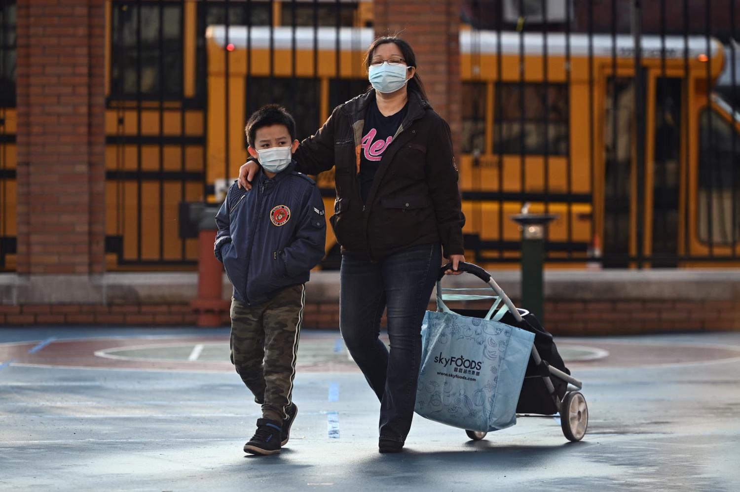 An accompanied student arrives at P.S. 7 Louis F. Simeone schoolyard as the masks policy for K through 12 is lifted, Queens, New York, NY, March 7, 2022. (Photo by Anthony Behar/Sipa USA)