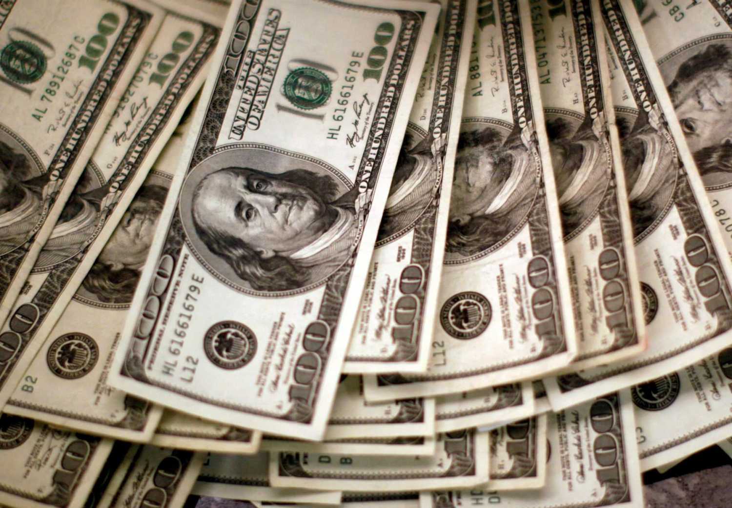 FILE PHOTO: U.S. dollars are counted out by a banker counting currency at a bank in Westminster, Colorado November 3, 2009. REUTERS/Rick Wilking/File Photo