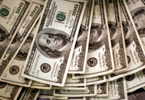 FILE PHOTO: U.S. dollars are counted out by a banker counting currency at a bank in Westminster, Colorado November 3, 2009. REUTERS/Rick Wilking/File Photo