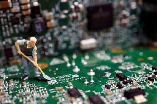A worker miniature is placed among printed circuit boards with semiconductor chips in this illustration picture. July 5, 2023. REUTERS/Florence Lo/Illustration/File Photo.