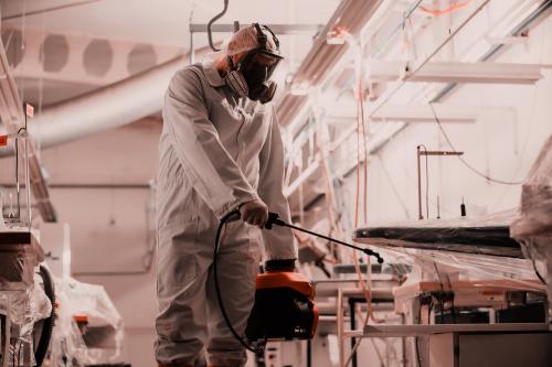 Person in hazemat suit sterilizing room.