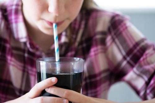 Young girl drinking soda.