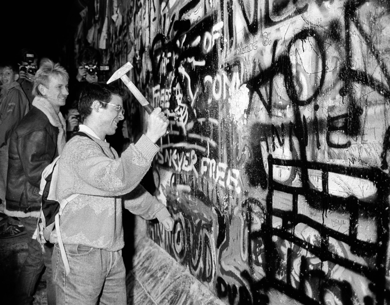 A MAN HAMMERS THE BERLIN WALL FILE PHOTO.