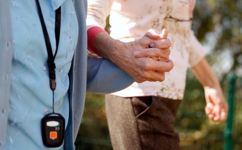 Resident Enid Roche takes a walk in the grounds of Foxholes Care Home, assisted by activities director Susan Davies as the spread of the coronavirus disease (COVID-19) continues, Hitchin, Britain March 25, 2020.