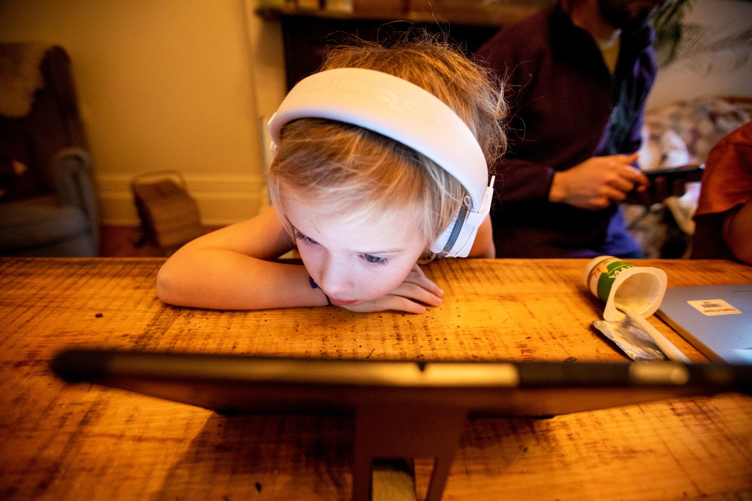 A child wearing headphones looking at a tablet computer.