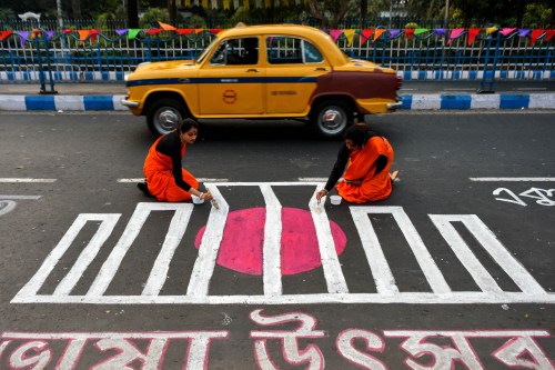 People are seen writing various messages on road in Bengali to commemorate International Mother Language Day