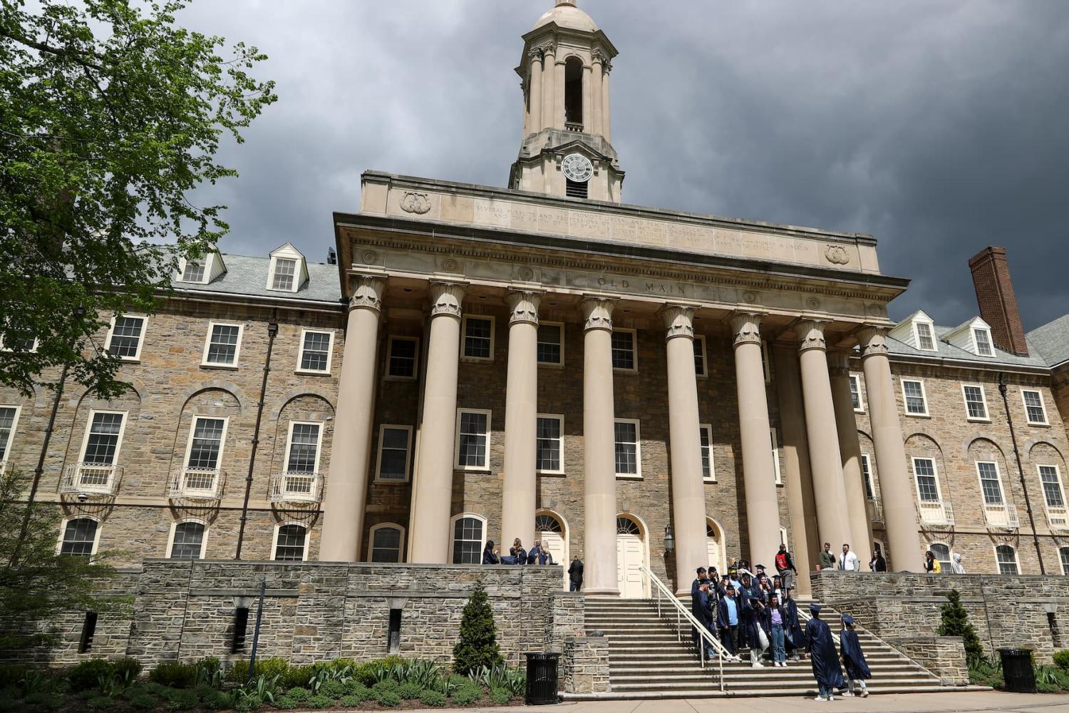 Students in caps and gowns pose for photos on the steps of Old Main on the campus of Penn State University in State College, Pa. on Sunday, April 23, 2023. Credit: Paul Weaver/Sipa USA)