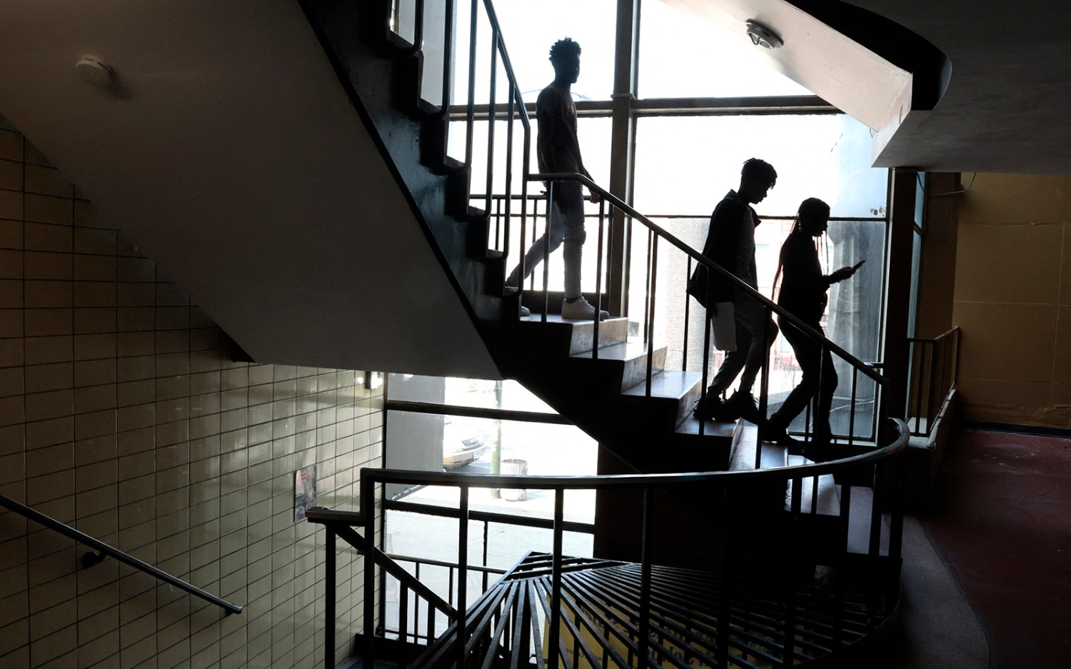 High school students in Chicago head down the stairs as they switch classrooms in June 2023.