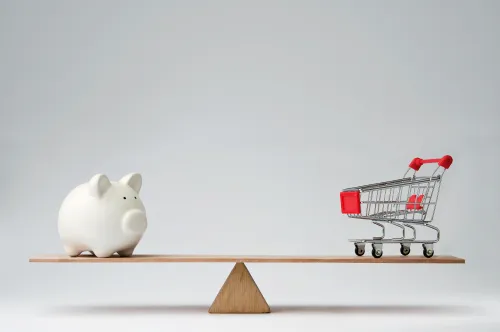 A piggy bank and a shopping cart in balance