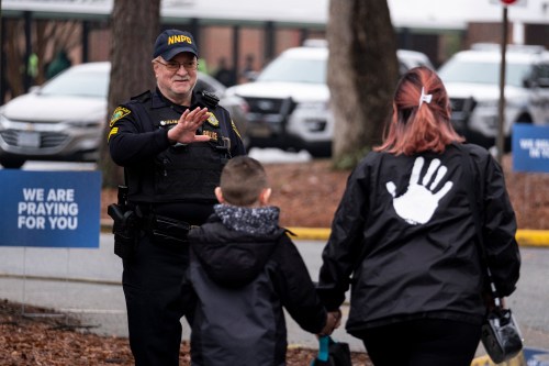 Sgt. Jamie Huling of the Newport News Police Department greets students as they return to Richneck Elementary in Newport News, Virginia, on Monday, Jan. 30, 2023, for the first time since a 6-year-old shot teacher Abby Zwerner three weeks prior. (Billy Schuerman/The Virginian-Pilot/TNS/ABACAPRESS.COM