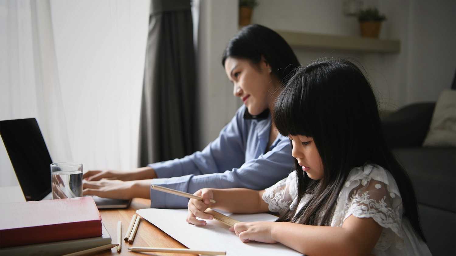 Family concept. Mom is working and taking care of her daughter too.
