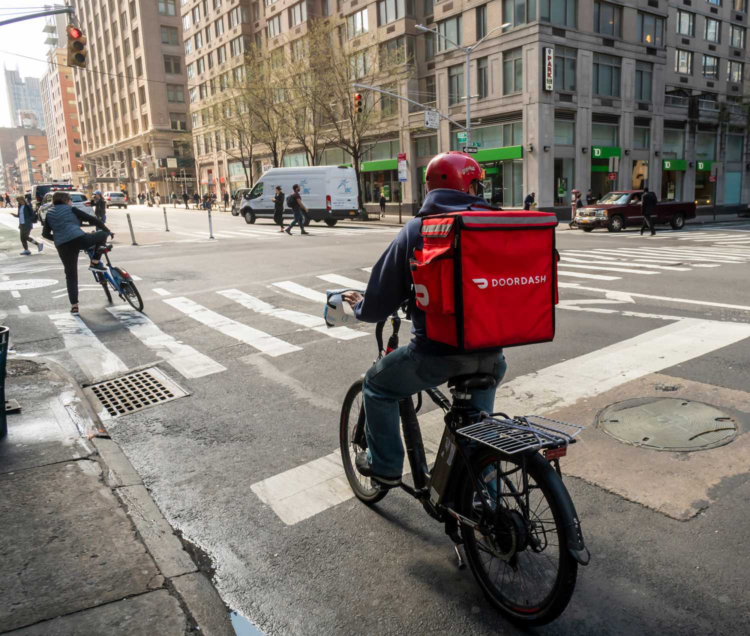 New York NY/USA-March 13, 2020 A delivery person with a DoorDash branded tote on his bicycle in the Chelsea neighborhood of New York