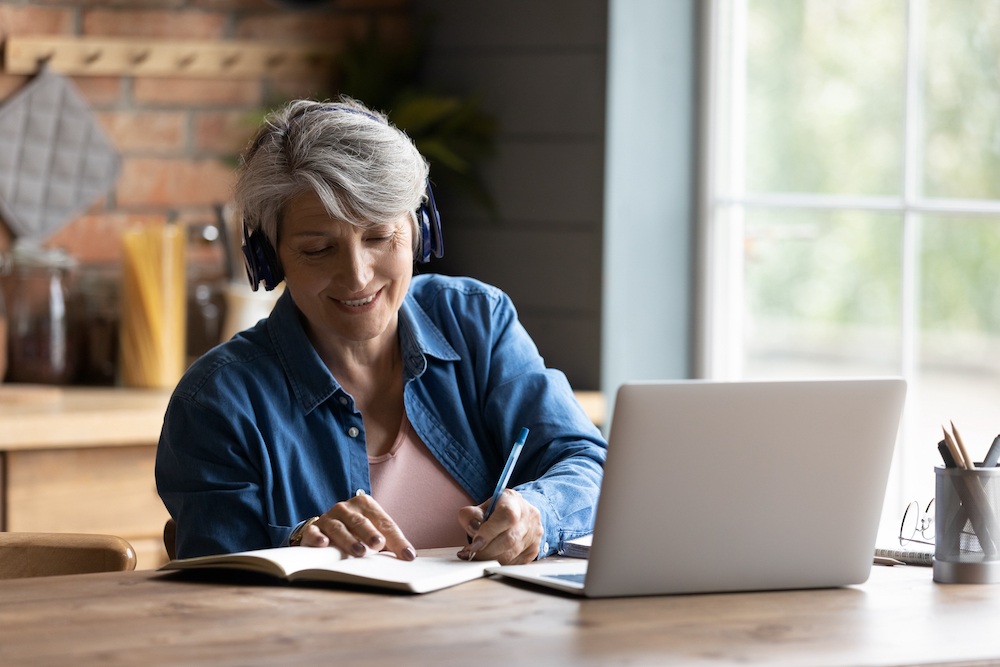 An older woman uses a laptop