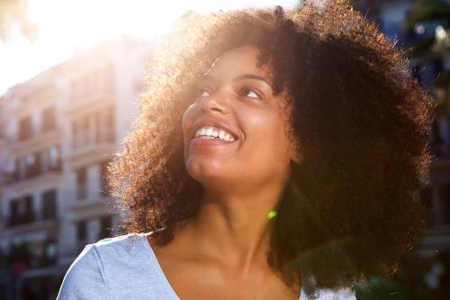 Close up side portrait of smiling african american woman outside in city