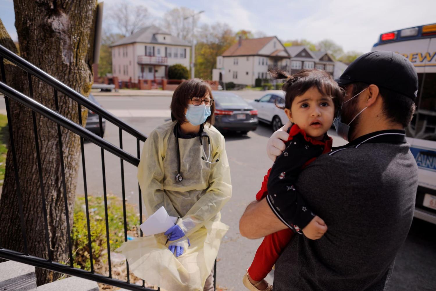Syed Kamal holds his one year-old daughter Fareeha outside their home as Boston Medical Center pediatrician Dr. Sara Stulac does a routine check-up in an effort to use an ambulance to bring routine care and scheduled vaccinations to children amid the coronavirus disease (COVID-19) outbreak in Boston, Massachusetts, U.S., May 8, 2020. REUTERS/Brian Snyder