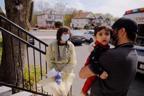 Syed Kamal holds his one year-old daughter Fareeha outside their home as Boston Medical Center pediatrician Dr. Sara Stulac does a routine check-up in an effort to use an ambulance to bring routine care and scheduled vaccinations to children amid the coronavirus disease (COVID-19) outbreak in Boston, Massachusetts, U.S., May 8, 2020. REUTERS/Brian Snyder