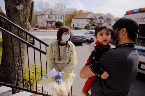 Syed Kamal holds his one year-old daughter Fareeha outside their home as Boston Medical Center pediatrician Dr. Sara Stulac does a routine check-up in an effort to use an ambulance to bring routine care and scheduled vaccinations to children amid the coronavirus disease (COVID-19) outbreak in Boston, Massachusetts, U.S., May 8, 2020.