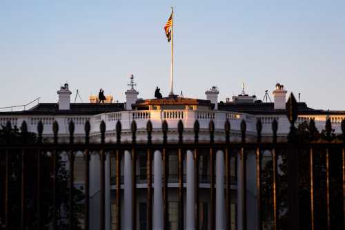 Snipers are seen walking on the roof of the White House in Washington, D.C. at sunset on February 9, 2022 (Photo by Bryan Olin Dozier/NurPhoto)