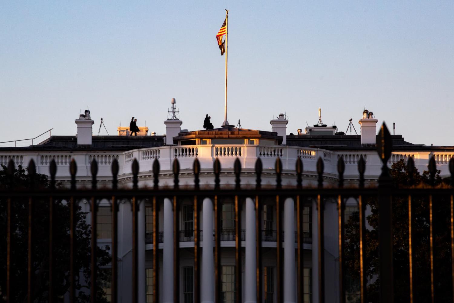 Snipers are seen walking on the roof of the White House in Washington, D.C. at sunset on February 9, 2022 (Photo by Bryan Olin Dozier/NurPhoto)