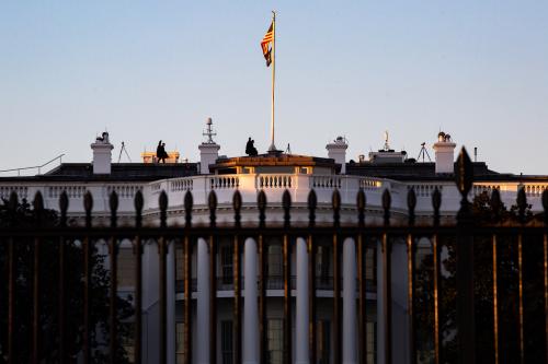 Snipers are seen walking on the roof of the White House in Washington, D.C. at sunset on February 9, 2022