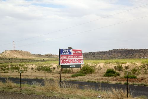 A sign advertising an online gun store is seen off I-40 in New Mexico USA on June 13, 2022. Hundreds of stores sell guns from big chains to small independent shops. In addition, there are dozens of gun shows that take place across the nation almost every weekend.