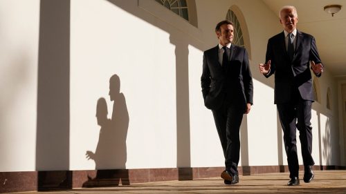 U.S. President Joe Biden and French President Emmanuel Macron walk along the Colonnade of the White House in Washington, U.S., December 1, 2022.